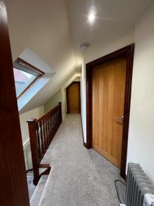 an attic hallway with a wooden door and stairs at Tewit Castle Adventures in Eryholme