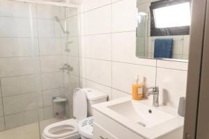 bagno bianco con servizi igienici e lavandino di Διαμερισμα 1 υπνοδωματίου a Aglantzia