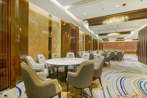 a conference room with tables and chairs and a chandelier at Hotel Levelup Signature in Amritsar