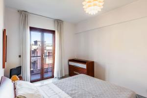 a white bedroom with a bed and a window at Capomulini House by Wonderful Italy in Acireale