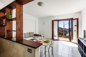 a kitchen and living room with a counter and a table at Capomulini House by Wonderful Italy in Acireale