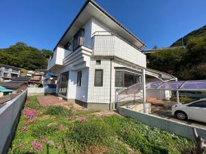 a white house with a car parked in front of it at Kashibesso Kiteki - Vacation STAY 26650v in Kitakyushu