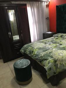 um quarto com uma cama, um banco e um espelho em Lake Boutique Hotel em Thohoyandou
