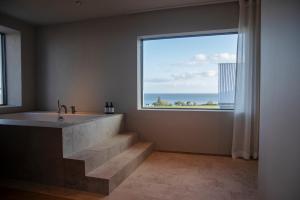 un bagno con vasca e una grande finestra di Hotel Vyn a Simrishamn