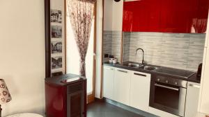 a kitchen with red cabinets and a sink at Adamello Brenta Sunshine in Madonna di Campiglio +21 photos
