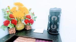 a black table with vases and flowers on it at Rooftop Floor with a big Room in New Delhi