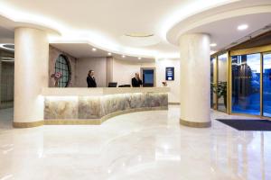 um lobby com duas pessoas de pé na recepção em Elite Hotel Dragos em Istambul