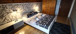 a bed in a room with a wall at Sobe Lara in Donji Milanovac