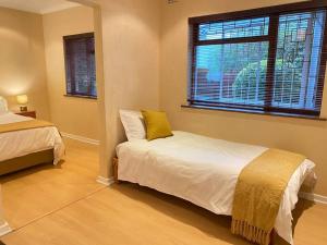 a bedroom with a bed and a yellow pillow at A Home in Timour Hall in Cape Town +24 photos