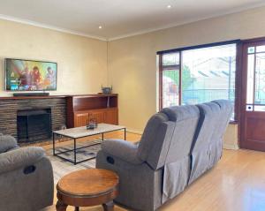 sala de estar con sofá y mesa en A Home in Timour Hall, en Ciudad del Cabo
