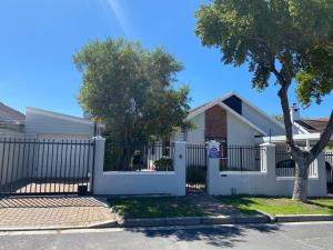 una cerca blanca frente a una casa en A Home in Timour Hall, en Ciudad del Cabo