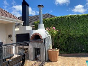 a building with a fireplace in the backyard of a house at A Home in Timour Hall in Cape Town