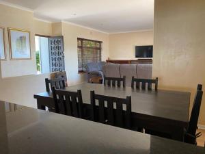 a dining room and living room with a table and chairs at A Home in Timour Hall in Cape Town