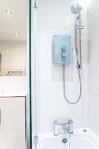 a shower in a bathroom with a sink at Smart Central Woking 1 Bedroom Apartment in Woking