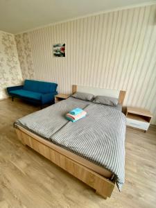 - une chambre avec un lit et une chaise bleue dans l'établissement Апартаменти поруч з метро Лівобережна, à Kiev