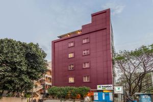 a red building with lights on the side of it at Treebo Trend Purple Square in Hyderabad