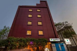um edifício alto vermelho com luzes nas janelas em Treebo Trend Purple Square em Hyderabad