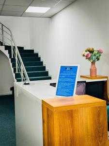 a desk with a sign on it in a room with stairs at Asia Hostel in Shymkent