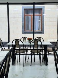 a dining table and chairs on a patio at Asia Hostel in Shymkent