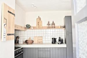 a kitchen with white tiled walls and a counter at Vakantiehuis Lott Duravel in Duravel