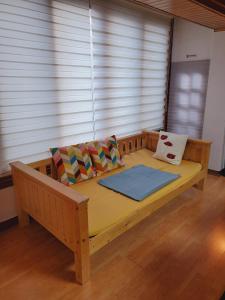 a large wooden bed in a room with windows at LINDSAY in Seoul