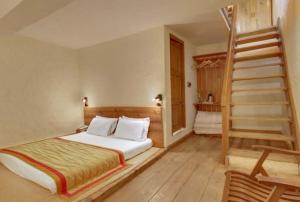 1 dormitorio con 1 cama y escalera de caracol en Chevron Eco Lodge Kausani, en Kausani
