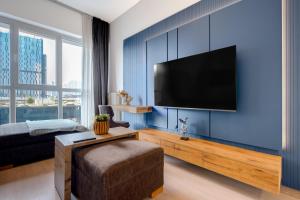 un salon avec une télévision à écran plat sur un mur bleu dans l'établissement Modern Residence Near Mall of Istanbul and Metro, à Istanbul