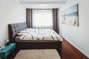 a small bedroom with a bed and a window at Cozy Nest in quiet neighbourhood, free parking in Ljubljana