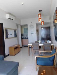 a living room with a table and a dining room at Mactan Newtown Beach Condo in Mactan