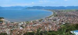 uma vista aérea de uma cidade e do oceano em Suítes Som do Mar em Caraguatatuba