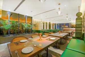 a restaurant with tables and chairs and plants at Hotel Levelup Signature in Amritsar