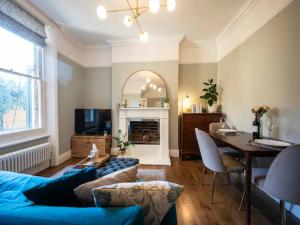 a living room with a blue couch and a table at Pass the Keys Boutique apartment 15 mins bus to Central London in London