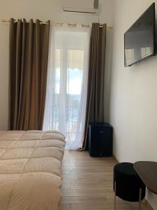 a bedroom with a bed and a large window at Mateo in Himare