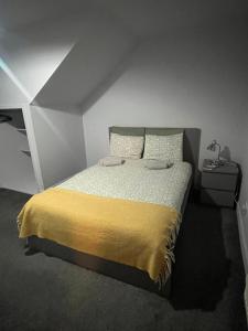 Boyds Entry flat Old town في إدنبرة: غرفة نوم بسرير وبطانية صفراء
