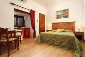 ein Schlafzimmer mit einem Bett und einem Tisch sowie eine Küche in der Unterkunft at 1 minute from San Marco square in Venedig