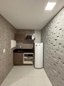 uma cozinha com um frigorífico e uma parede de azulejos em Apto confort bem localizado Macambira em Campina Grande
