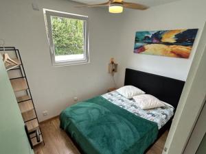 a small bedroom with a bed and a window at Apb-Spa cottages et Apb BnB avec piscine in Saint-Jean-de-Monts
