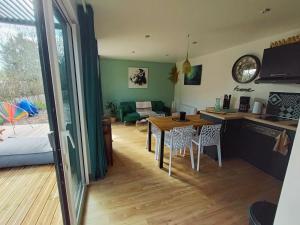 a kitchen and living room with a table and chairs at Apb Spa locations avec jacuzzi privatif in Saint-Jean-de-Monts