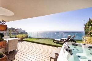 een terras met een hot tub en uitzicht op de oceaan bij Serenity Amadores in Puerto Rico de Gran Canaria