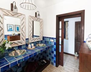 a bathroom with two sinks and two mirrors at MoonLava: Apto, Piscina, WiFi in Yaiza