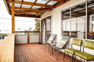 a screened porch with chairs and a table at Wave Side Cottage Scamander Sleeps 5 in Scamander