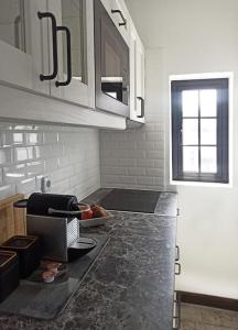 a kitchen with white cabinets and a black counter top at MoonLava: Apto, Piscina, WiFi in Yaiza