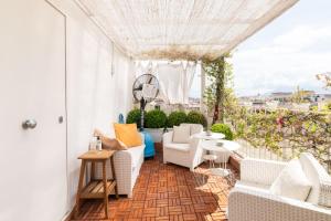einen Balkon mit weißen Möbeln und Aussicht in der Unterkunft LaLoren By DomusExtra in Neapel