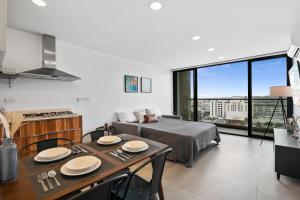 a living room with a bed and a table and a kitchen at Downtown Apartment with Balcony City View, Gym & Lounge in Tijuana