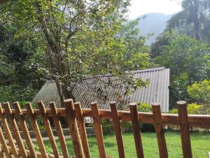 una valla de madera en un patio con un árbol en Ella Wood Cabin en Ella