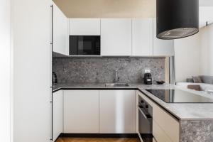 a kitchen with white cabinets and a sink at San Martino - Luxury Apartments By Design Club Collection in Bologna