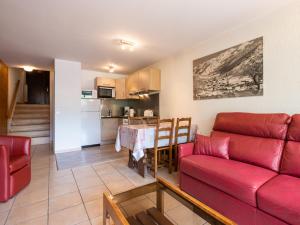 un soggiorno con divano rosso e una cucina di Appartement La Clusaz, 2 pièces, 4 personnes - FR-1-304-12 a La Clusaz