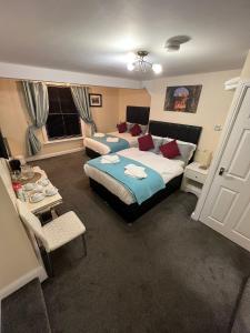 a bedroom with two beds and a table and a window at ABBEY HOLIDAY ACCOMMODATiON in Whitby