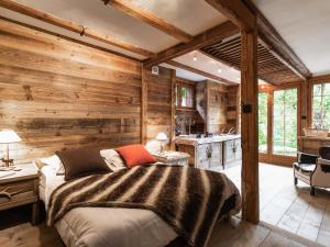 ein Schlafzimmer mit einem Bett und einer Holzwand in der Unterkunft Chalet La Clusaz, 6 pièces, 10 personnes - FR-1-304-162 in La Clusaz