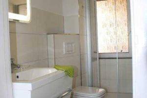 a bathroom with a tub and a toilet and a sink at Bungalow Fam Müller Prüter in Kühlungsborn
